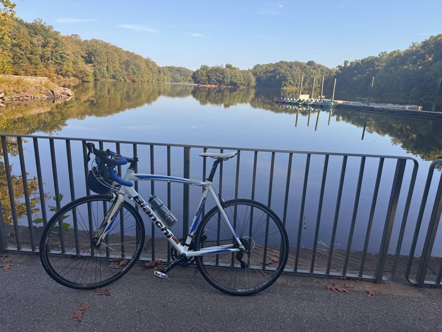 Bianchi bike, white with blue frame details and blue handelbar wrap, in front of Lake Needwood, Md.