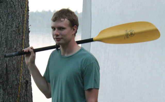 Me, holding half a kayak paddle, in front of an outdoor projection screen set up for Rock Band 3. Yup.